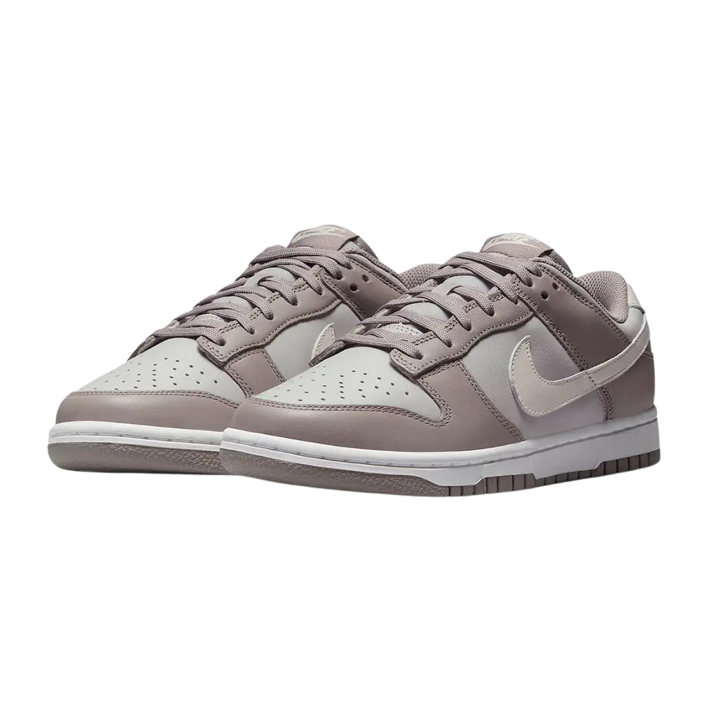 Pair of Nike Dunk Low sneakers in beige on a white background